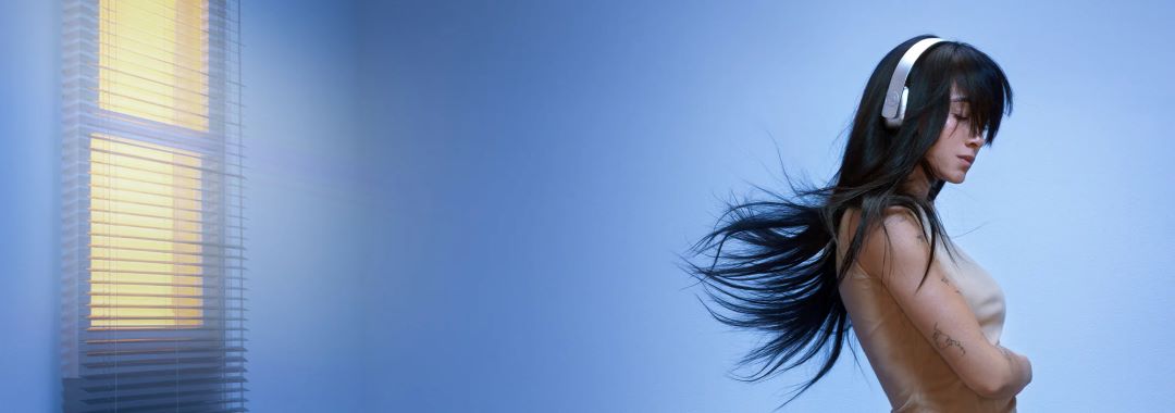 Portada del Disco Cuarto Azul de Aitana. Aitana con cascos puestos y el pelo al aire.