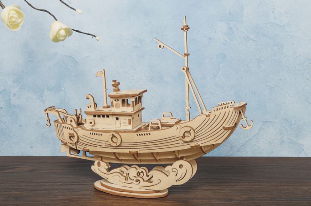 Puzzle 3D de madera con forma de barco artesanal sobre una mesa, elaborado con piezas detalladas y acabado natural, representando la creatividad manual y la precisión del diseño en madera