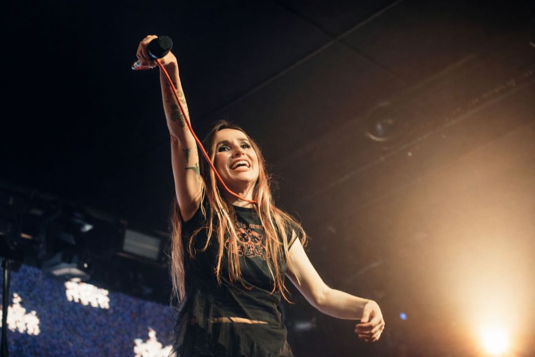 Zahara, en concierto, elevando el micrófono