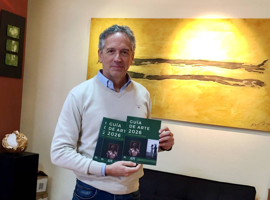 Guia de Arte Esencial. Francisco Arroyo con dos ejemplares en la mano.