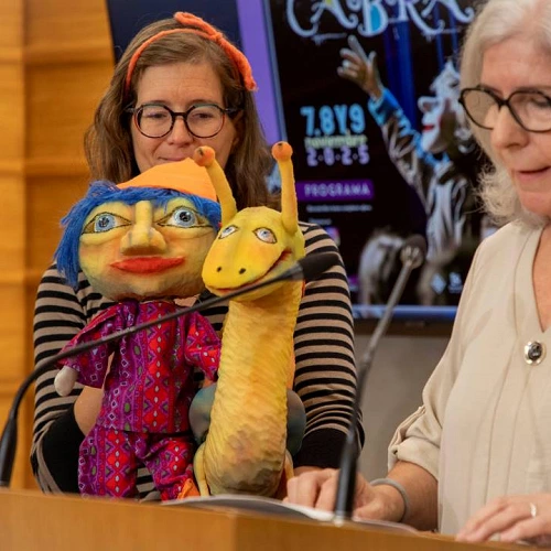 La Directora de la Compañía Titiricabra junto a una compañera y dos títeres