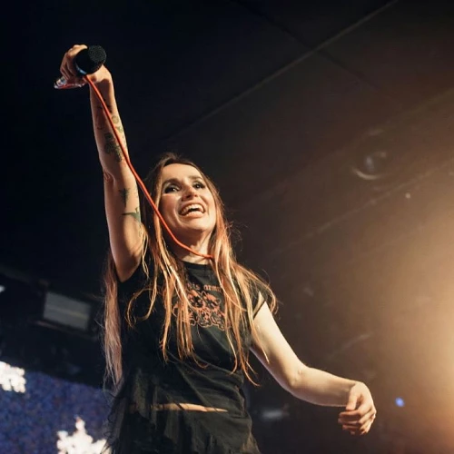 Zahara, en concierto, elevando el micrófono